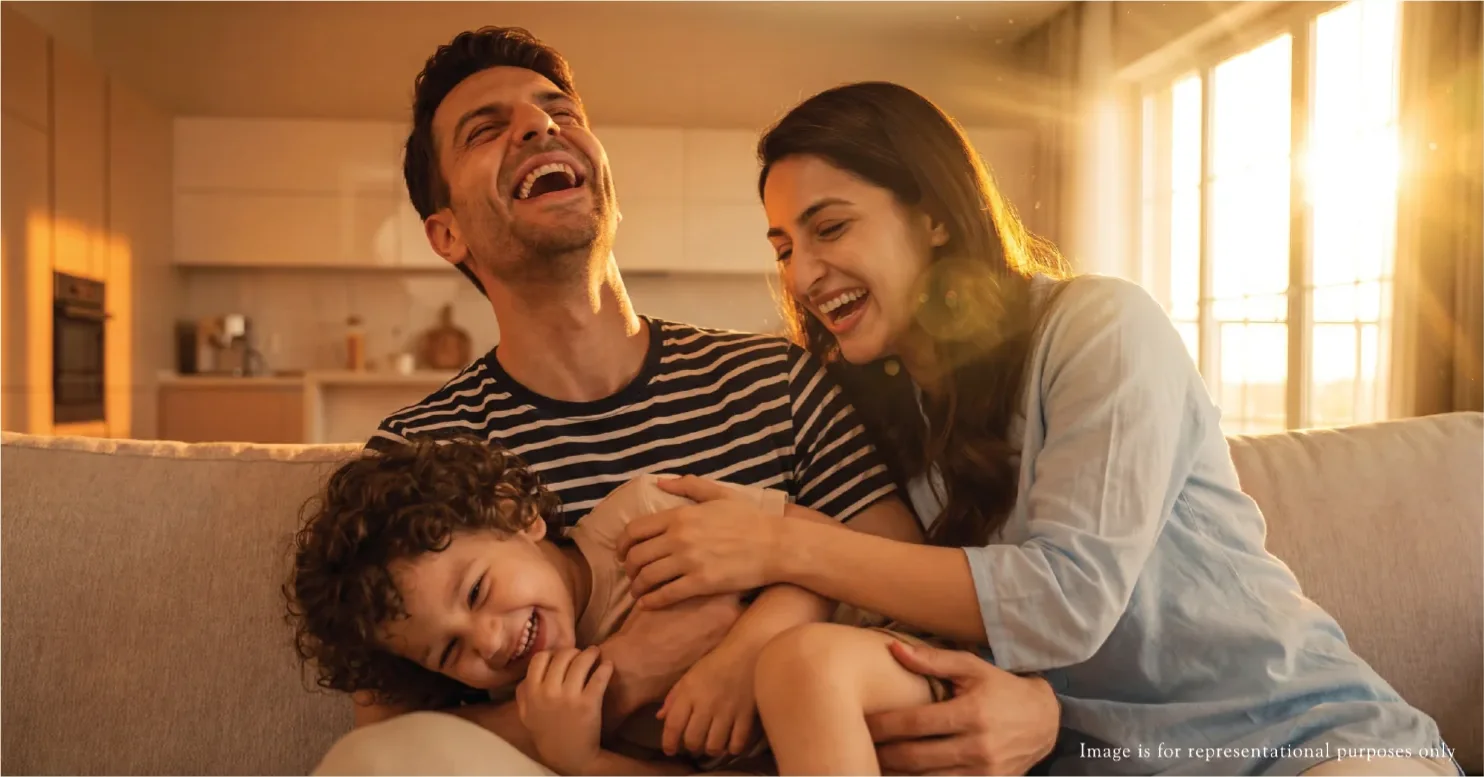 Family in a sunlit living room with floor-to-ceiling windows, representative of the 3 BHK interiors at Rustomjee Urban Woods