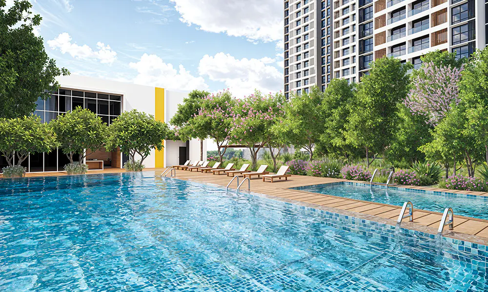 Swimming pool with a timber deck and flowering trees at Rustomjee Urban Woods